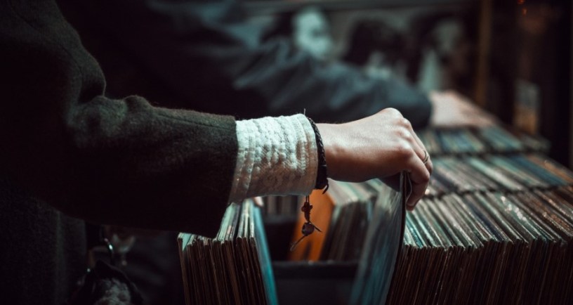 person going through record store shelves to illustrate leaving home by michael goth
