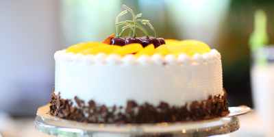 white round cake topped with yellow slice fruit