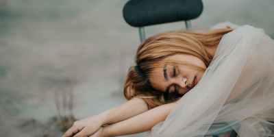 reflective asian woman leaning on chair in pond