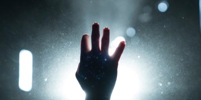 hand reaching toward light to signify redemption graphic for article on CS Lewis and Russell Kirk