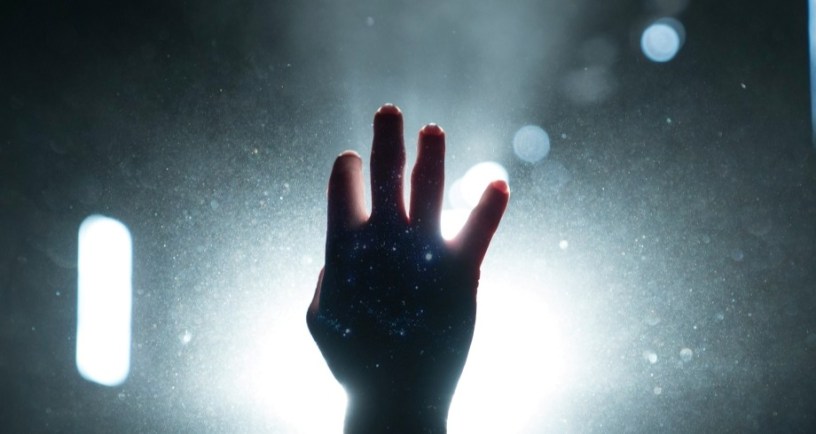 hand reaching toward light to signify redemption graphic for article on CS Lewis and Russell Kirk